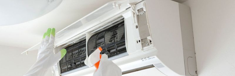 HVAC technician repairing an air conditioner unit in Cardiff by the Sea CA